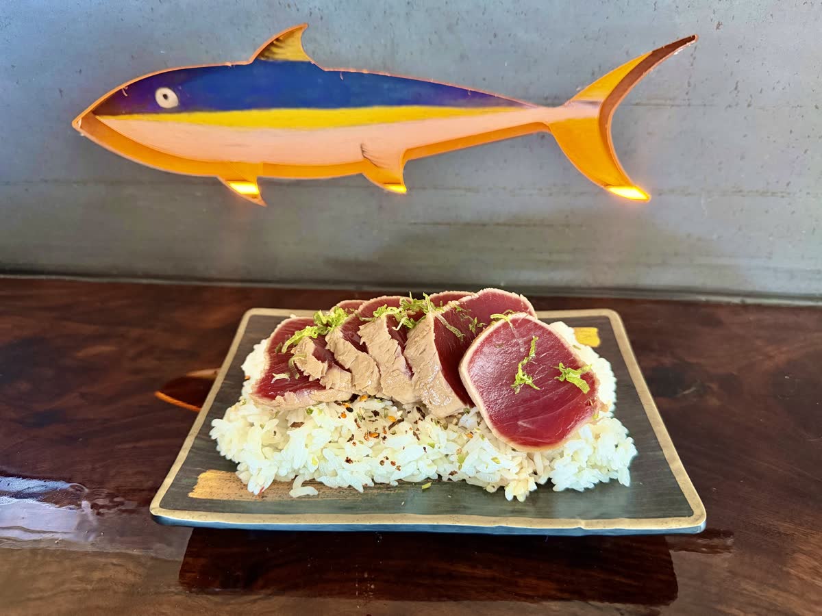 Seared ahi tataki plated beneath the painted tuna