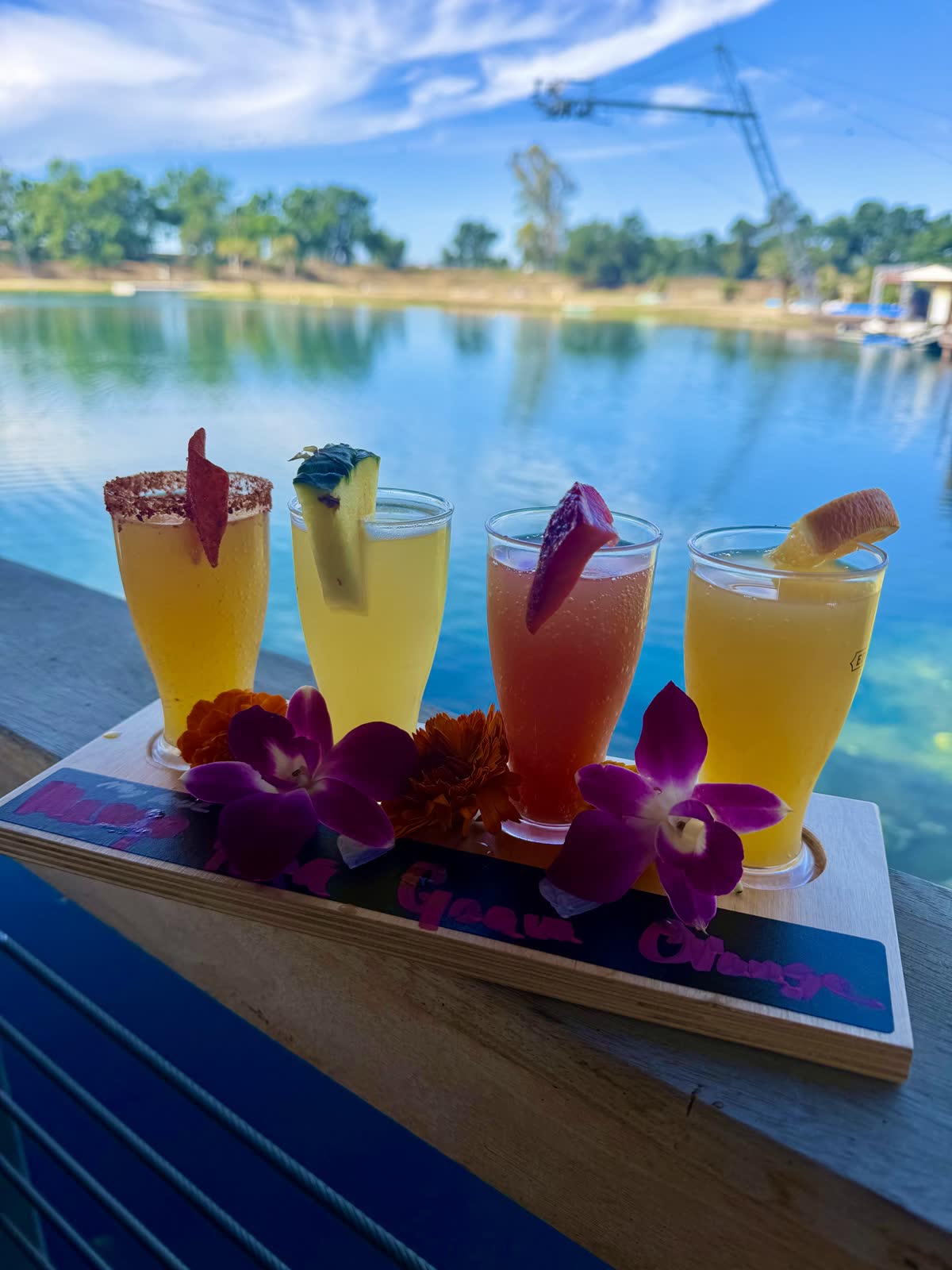 Flight of four mimosas with orchids served on the Costa Fuego deck over the lake