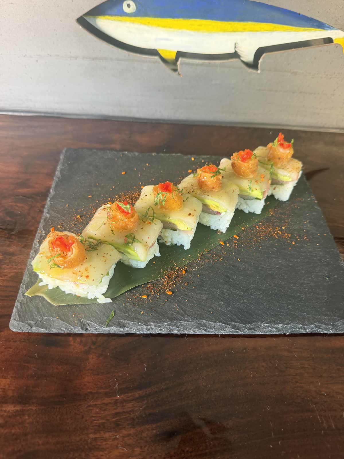Halibut oshi beneath the painted yellowtail wall art