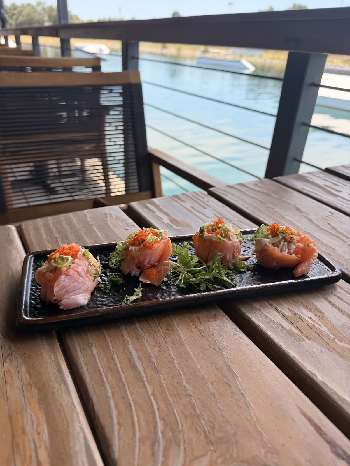 Salmon crab bites on a deck table with the wakeboard ramp and turquoise channel behind
