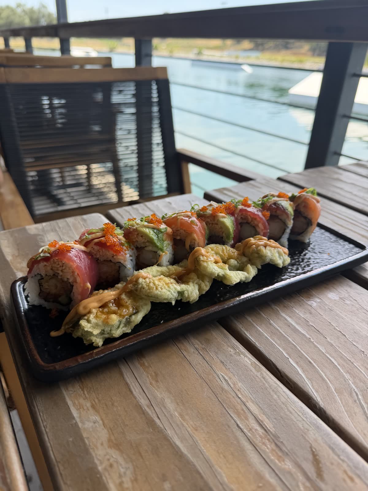 Costa Fuego signature sushi roll with tempura jalapeno on the deck rail over the lake